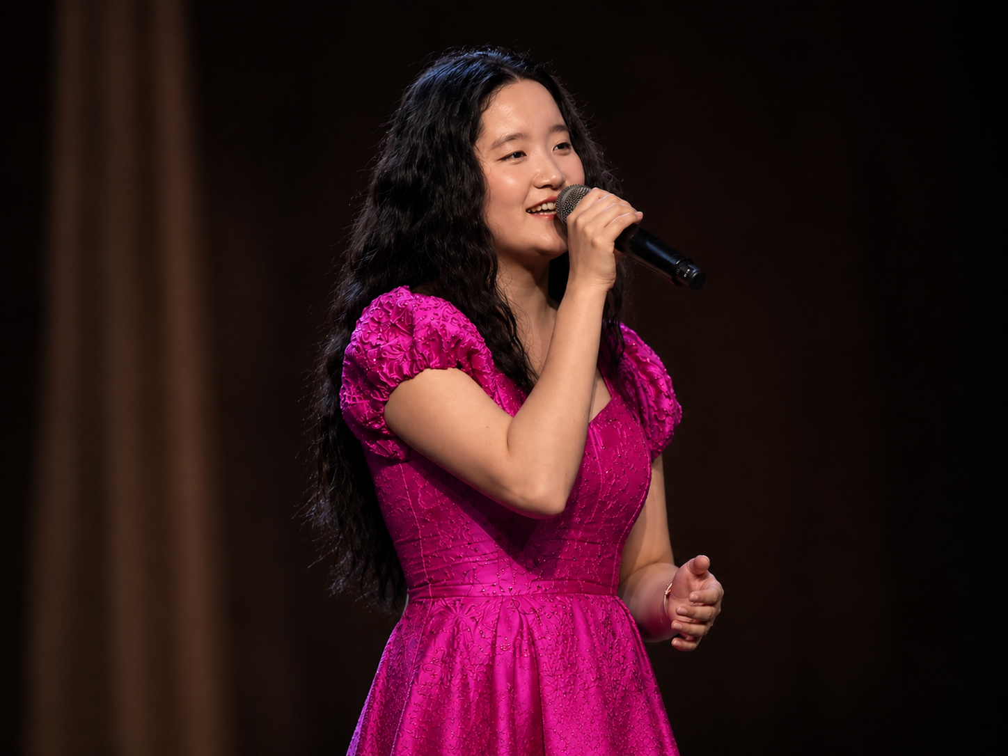Chloe Cox performing in pink dress